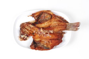 Derin kızarmış tilapia balık gevrek kırmızı soğan tepesinde. 