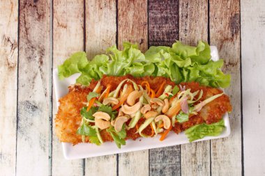 Baharatlı Dolly'nin balık salatası rulo yeşil mango ile kızartılmış.