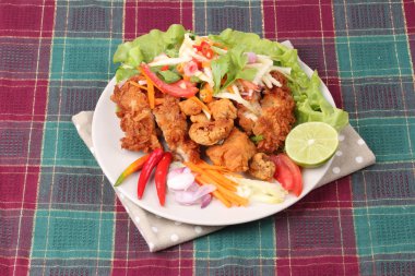 Rulo yeşil mango baharatlı kızarmış tavuk salatası .