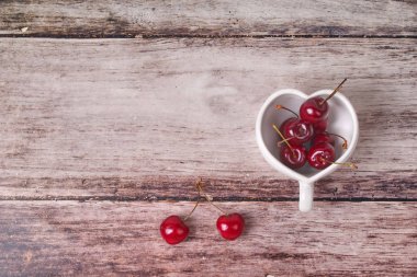 Kiraz Şili ve kalp şeklinde kupa üzerinde ahşap.