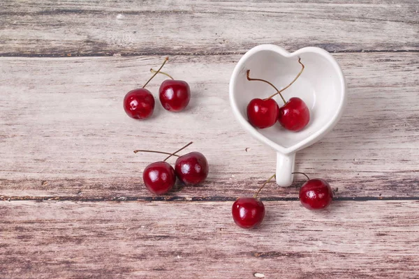 Kiraz Şili ve kalp şeklinde kupa üzerinde ahşap.