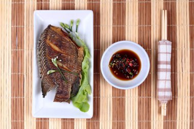 Derin yağda kızartılmış küçük tilapia Balık baharatlı fasulye sos ile.