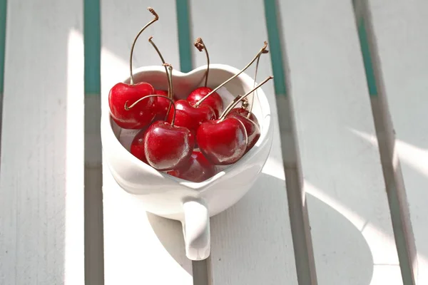 Kirschen Chili im herzförmigen Becher auf Holz . — Stockfoto