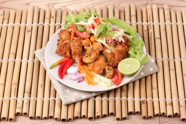 Rulo yeşil mango baharatlı kızarmış tavuk salatası .