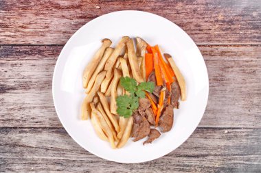 Fried eryngii mantar domuz karaciğer ve havuç ile.