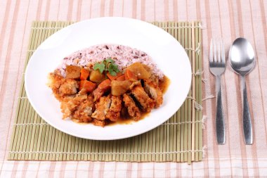 Japon sarı köri tavuk ile kahverengi pirinç tepesinde. 