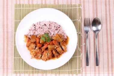 Japon sarı köri tavuk ile kahverengi pirinç tepesinde. 