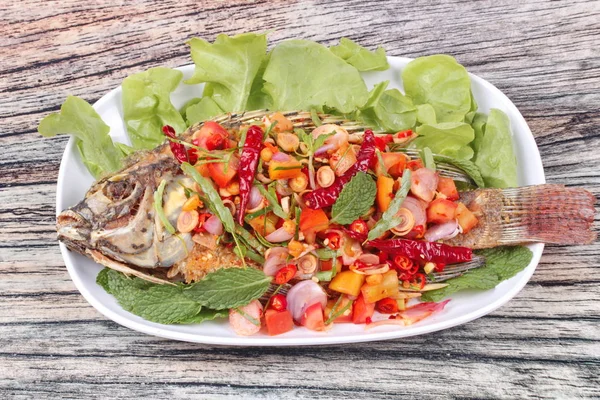 Ensalada de tilapia frita picante y agria con hojas de tamarindo bebé  . — Foto de Stock