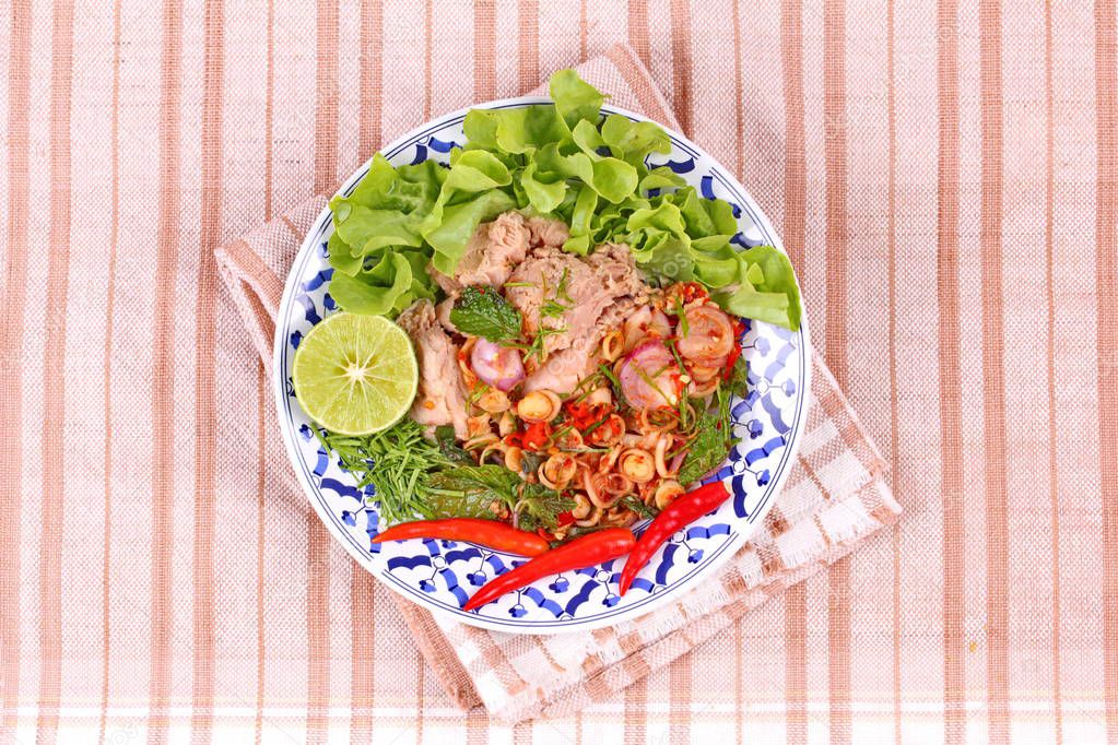 Spicy and sour mixed herb salad with tuna served .