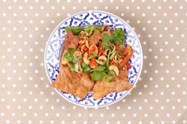 Baharatlı ve ekşi karışık ot salatası gevrek domuz eti ile hizmet .