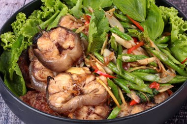 Baharatlı kızarmış börülce ve fesleğen ile dilimlenmiş yayın balığı.