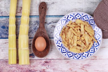 Fried yumuşak bambu kutup sürgünleri ile yumurta ve mutfak ekipmanları coo