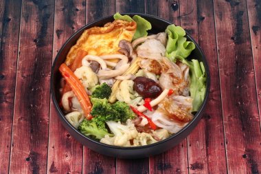 Karışık sebze çorbası kızarmış büyük noodle omlet ile tepesinde.