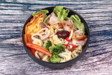 Karışık sebze çorbası kızarmış büyük noodle omlet ile tepesinde.