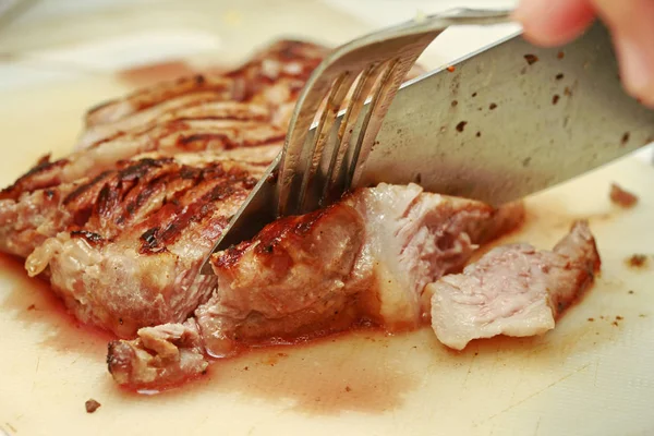 Bıçak ve çatal dilimlenmiş domuz biftek için kullanın . — Stok fotoğraf