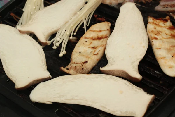 Champiñones a la parrilla, Eryngii y champiñones aguja dorada, en un asado — Foto de Stock