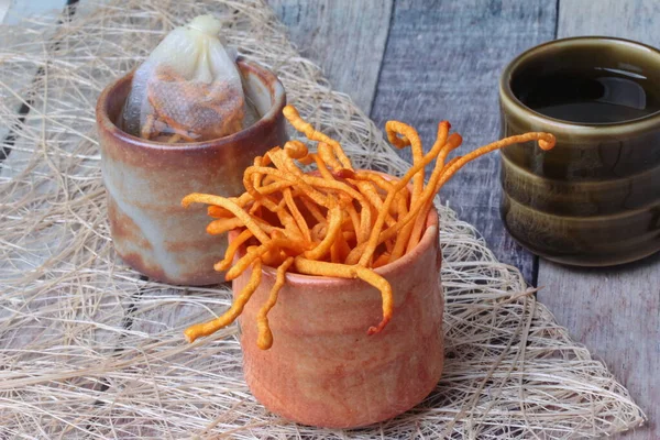 Altın Cordyceps mantarı fincanda, bitkisel çay poşeti altın cordyceps militaris ve fincanda çay ahşap üzerinde servis edilir.