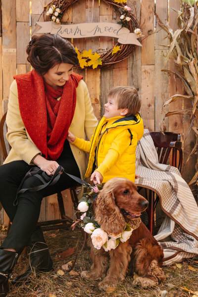 Happy young mom with son in autumn forest and with decor