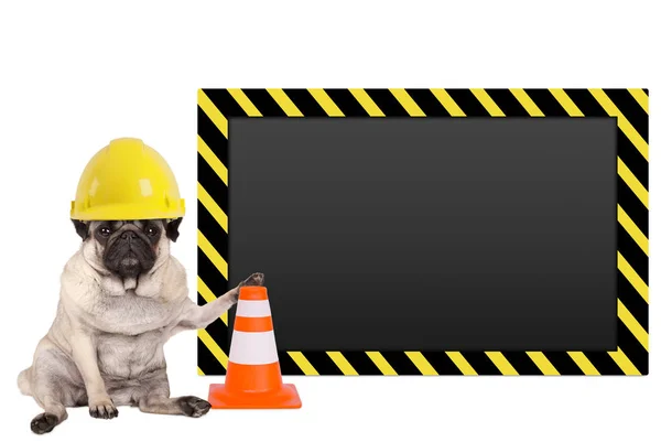 Cão pug com capacete de segurança do trabalhador de construção amarelo e sinal de aviso em branco — Fotografia de Stock