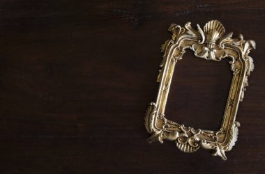 Antiq altın fotoğraf çerçevesi rokoko tarzı, karanlık rustik ahşap arka plan üzerinde