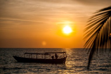 portakal rengi gün batımı ve denizde tekne 