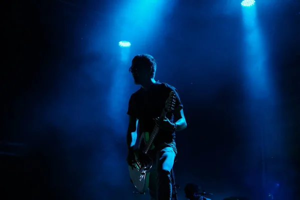 Silhueta de um guitarrista em um fundo escuro . — Fotografia de Stock