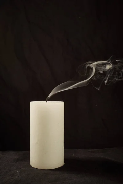 Extinct candle and smoke on a black background.