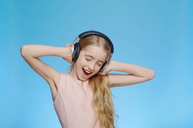 Kulaklıklı sarışın kız müzik dinliyor. İzole edilmiş yarım boy portre. Duygu ve neşe kavramı