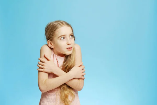 Nettes kleines Mädchen friert. Nettes kleines Mädchen umarmte sich selbst. — Stockfoto