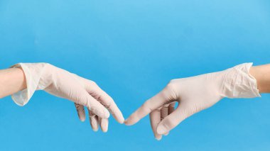 Karantina sırasında eldivenli iki el birbirine dokunur. Karantina konsepti. 