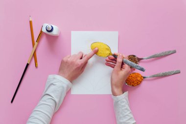 Çocuk zanaatı yapmak için adım adım talimat. Üçüncü adım: Yapıştırıcıya mısır gevreği dök. İnce motor becerilerin gelişimi kavramı.