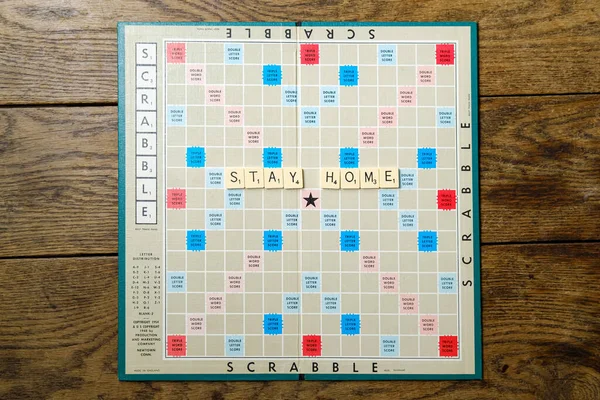 Lviv şehri, Ukrayna, Mart 2020. Scrabble tahtası ve "Evde Kal" tabelası. Karantina sırasındaki boş konsept. — Stok fotoğraf