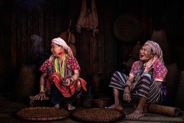 CHIANGMAI, THAILAND 24 Şubat 2020 'de Tayland' ın Chiangmai şehrinde yaşlı bir kabile kadını elleri başının üzerinde oturuyordu ve gözlerini kapatıyordu..