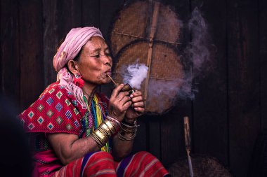 CHIANGMAI, THAILAND 24 Şubat 2020 'de Tayland' ın Chiangmai şehrinde yaşlı bir kabile kadını elleri başının üzerinde oturuyordu ve gözlerini kapatıyordu..