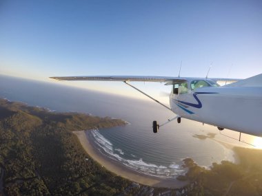 Vancouver, British Columbia, Kanada kuzeyindeki - 22 Ekim 2017 - gökte uçan uçak bulutlar dağlar çevresinde canlı bir akşam gün batımına sırasında kaplı.