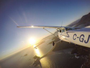 Estevan, Vancouver Adası, British Columbia, Kanada - 29 Haziran 2017 - küçük Cessna 172 uçak uçan bir parlak güneş sırasında Pasifik kıyısında şehir çevresinde