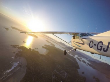 Estevan, Vancouver Adası, British Columbia, Kanada - 29 Haziran 2017 - küçük Cessna 172 uçak uçan bir parlak güneş sırasında Pasifik kıyısında şehir çevresinde