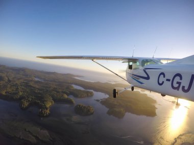 Estevan, Vancouver Adası, British Columbia, Kanada - 29 Haziran 2017 - küçük Cessna 172 uçak uçan bir parlak güneş sırasında Pasifik kıyısında şehir çevresinde