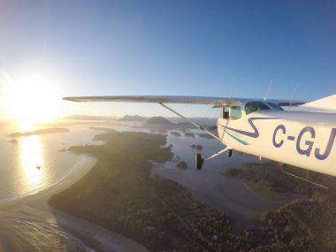 Estevan, Vancouver Adası, British Columbia, Kanada - 29 Haziran 2017 - küçük Cessna 172 uçak uçan bir parlak güneş sırasında Pasifik kıyısında şehir çevresinde