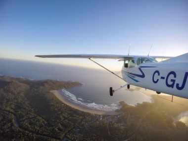 Estevan, Vancouver Adası, British Columbia, Kanada - 29 Haziran 2017 - küçük Cessna 172 uçak uçan bir parlak güneş sırasında Pasifik kıyısında şehir çevresinde