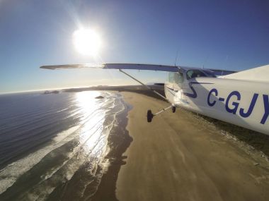 Estevan, Vancouver Adası, British Columbia, Kanada - 29 Haziran 2017 - küçük Cessna 172 uçak uçan bir parlak güneş sırasında Pasifik kıyısında şehir çevresinde