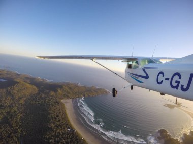 Estevan, Vancouver Adası, British Columbia, Kanada - 29 Haziran 2017 - küçük Cessna 172 uçak uçan bir parlak güneş sırasında Pasifik kıyısında şehir çevresinde