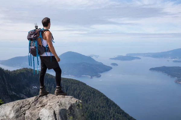 Latin Amerikalı erkek Hiker güzel manzara bakan kayalık tepe üstünde duruyor. Aslanlar Mountain, Kuzey Vancouver, British Columbia, Kanada kadar yol üzerinde gerçekleştirilen resmi.