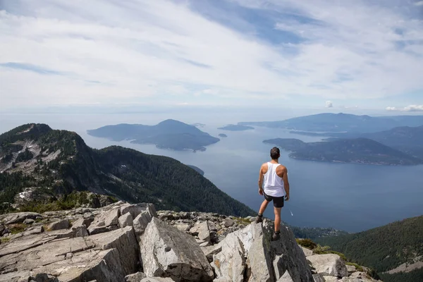 Latin Amerikalı erkek Hiker güzel manzara bakan kayalık tepe üstünde duruyor. Aslanlar Mountain, Kuzey Vancouver, British Columbia, Kanada kadar yol üzerinde gerçekleştirilen resmi.