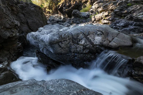 Fresh water flowing around the smooth rocks in the canyon. Taken in Lynn Valley, North Vancouver, BC, Canada.