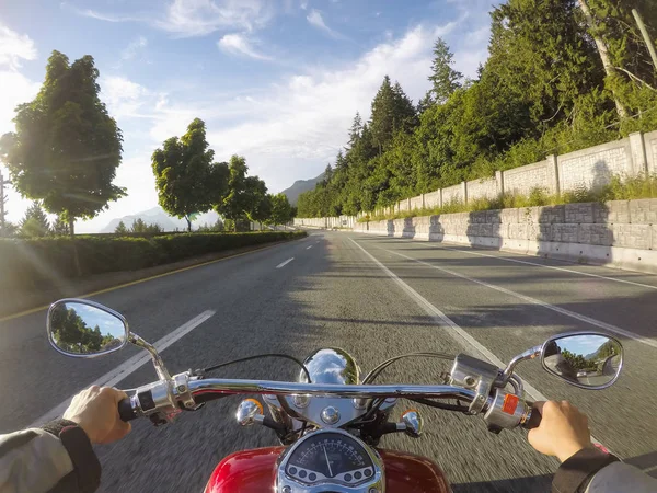 Riding a cruiser motorcycle on Sea to Sky Highway from Vancouver to Squamish, British Columbia, Canada. Taken during a sunny summer day.