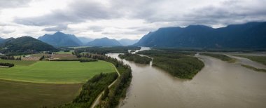 Aerial view of the Farm lands, fraser river and the beautiful mountain landscape. Taken in Agassiz, British Columbia, Canada. clipart