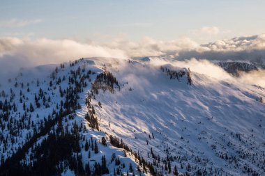 Gerçeküstü hava manzaralı Dağları nın parlayan bulutlar kaplı. Alınan Kuzey Vancouver, British Columbia, Kanada, gün batımı sırasında.