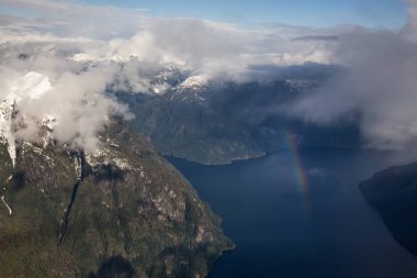 Sunshine Coast, British Columbia, Kanada kuzeyindeki Jervis giriş. Bir hava açısından bakıldığında bir gökkuşağı bulutlar ile yağmurlu bir akşam sırasında alınan.