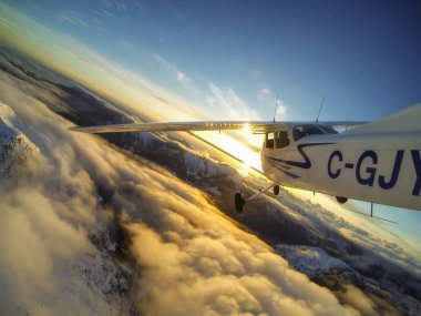 North West Vancouver, British Columbia, Kanada - 30 Mart 2017 - dışında küçük bir Cessna 172 gün batımı sırasında dağların uçan uçak bakış.